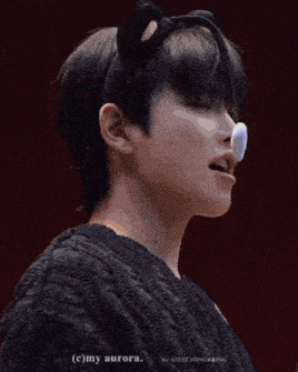 a close up of a person wearing a cat ear headband and a black sweater