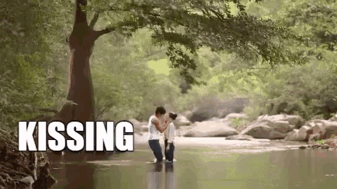 a man and woman are kissing in a river with the word kissing above them