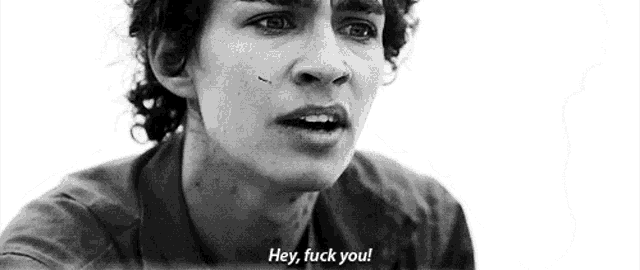 a black and white photo of a man with curly hair saying hey , fuck you .