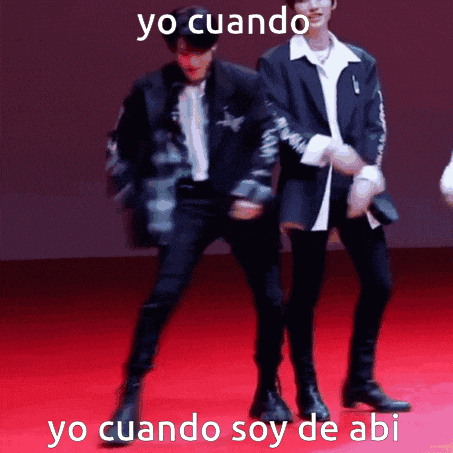 two men in suits are dancing on a red carpet with the words yo cuando yo cuando soy de abi below them .