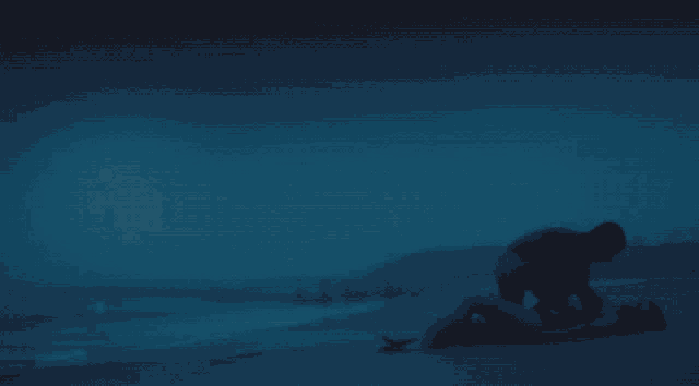 a man and woman are laying on a beach at night with a full moon in the background