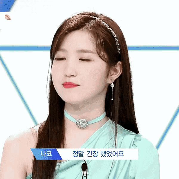 a woman wearing a choker and earrings has a name tag that says ' na ko ' on it
