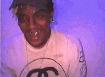 a man wearing a hat and a white shirt with a chanel logo on it .
