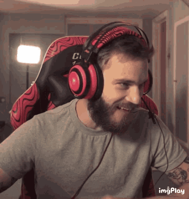 a man with a beard wearing headphones and a gray shirt with imgplay on the bottom