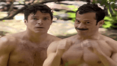two shirtless men are standing next to each other and one has a mustache .