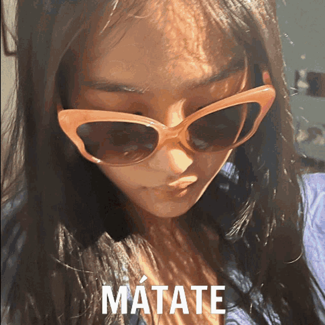 a woman wearing sunglasses has matate written on the bottom of her face