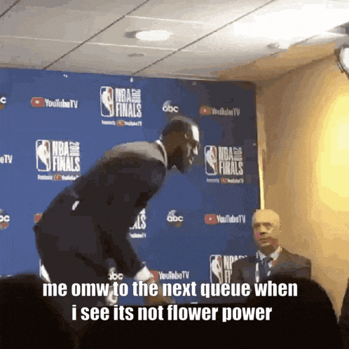 a man stands in front of a wall that says nba finals on it