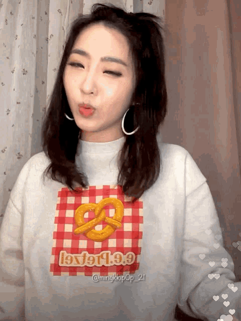 a woman wearing a sweater with a pretzel on it and the word love on it