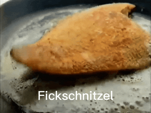 a piece of chicken is being cooked in a frying pan with the words fickschnitzel written below it