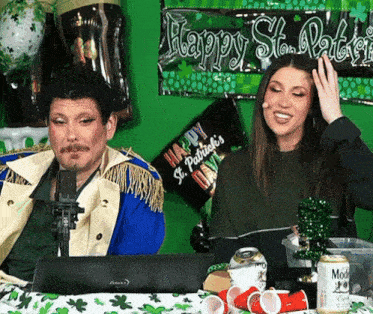 a happy st. patrick 's day sign is behind a man and a woman