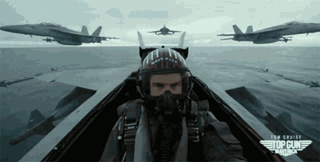 a man wearing a helmet that says maverick is flying a plane