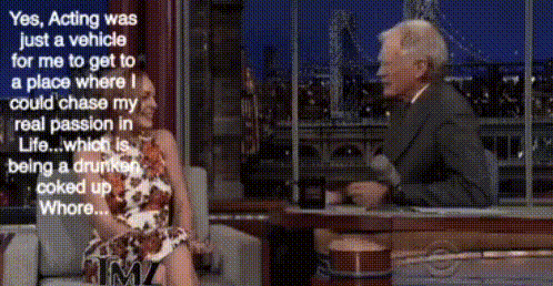 a woman is sitting on a couch talking to a man in a suit .