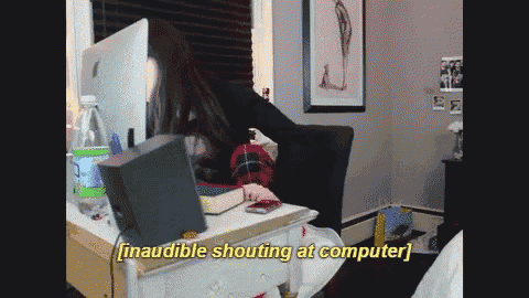 a woman sitting in front of a computer with the words inaudible shouting at computer below her