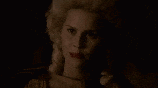 a close up of a woman 's face with a wig on in the dark .