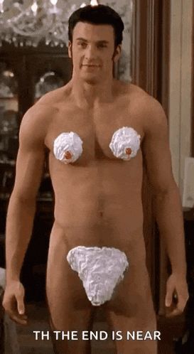 a naked man with whipped cream on his breasts and underwear is standing in a room .