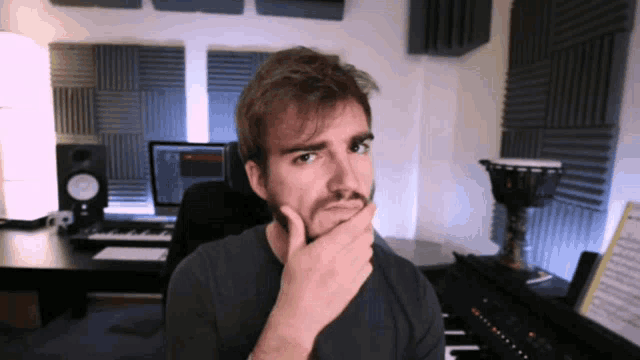 a man with a beard is sitting in front of a keyboard