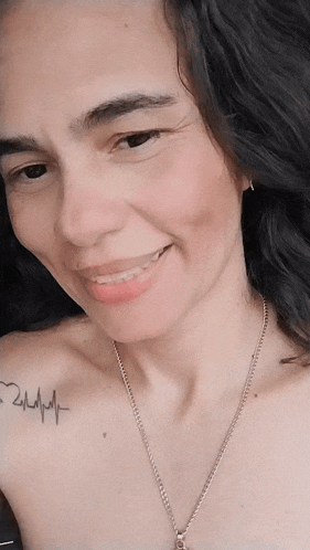 a woman has a tattoo of a heartbeat on her chest