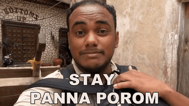 a man wearing a backpack with the words stay panna porom on it
