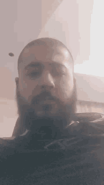 a close up of a man 's face with a beard .