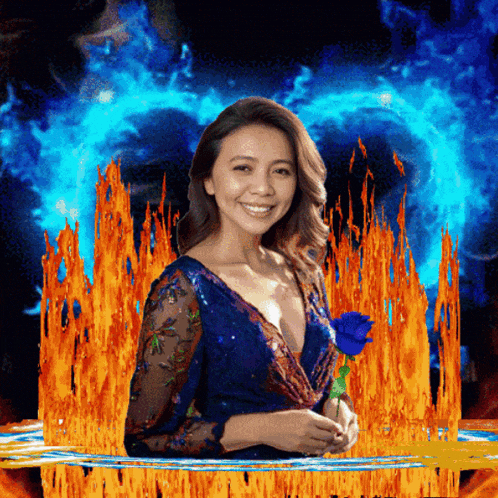 a woman in a blue dress holding a blue rose in front of flames