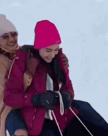 a woman wearing a pink hat is riding on the back of another woman