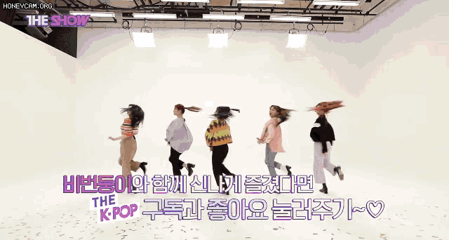 a group of girls are jumping in the air on a stage with the show written in purple letters