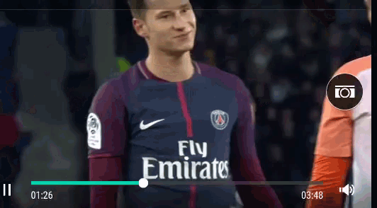 a soccer player wearing a fly emirates jersey stands in front of a camera