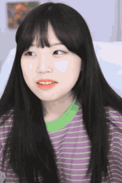 a girl with long black hair wearing a striped shirt