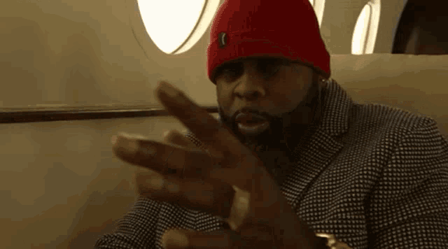 a man wearing a red beanie and a black and white jacket
