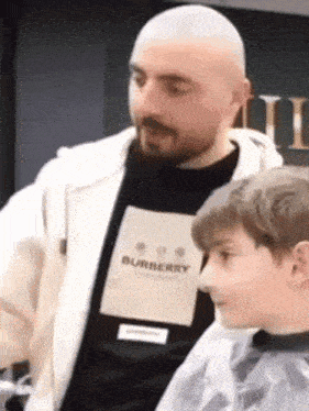a man wearing a burberry shirt talks to a boy