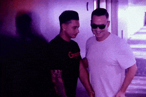 two men are standing next to each other with one wearing a shirt that says g