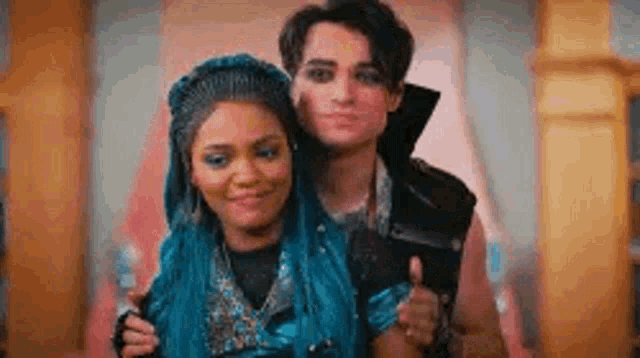 a man and a woman are posing for a picture together . the woman has blue hair .