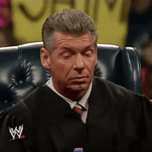 a man in a black robe and tie is sitting in a chair with his eyes closed .
