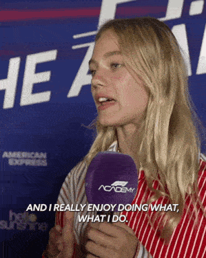 a woman talking into a microphone with the words " and i really enjoy doing what what i do " behind her
