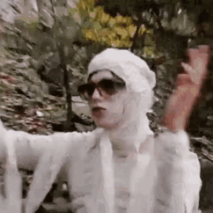 a man is wearing a mummy costume and sunglasses .