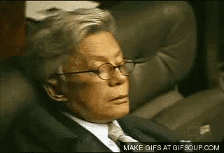 a man in a suit and tie is sitting in a chair with his eyes closed