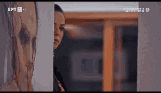 a woman peeking out from behind a wall with ept 1 hd on the bottom right