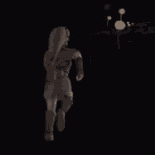 a person is walking in the dark with a balloon in the background .
