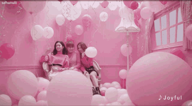 a group of girls are surrounded by pink balloons and the word joyful is on the bottom right