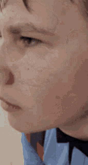 a close up of a person 's face with a bandage on his nose .