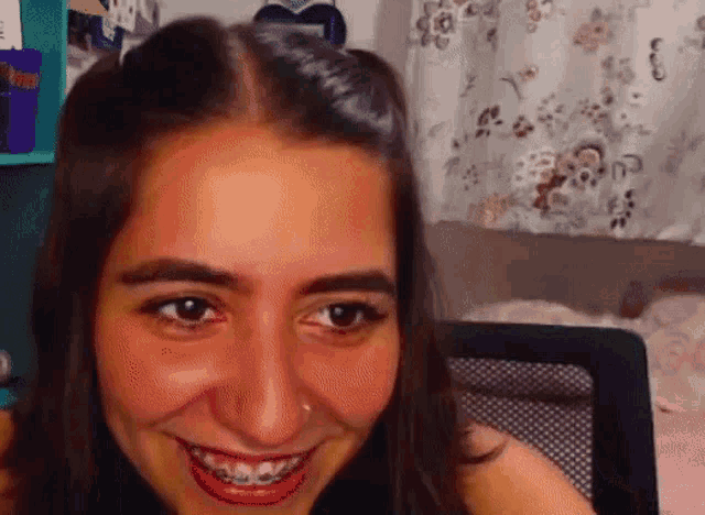 a close up of a woman 's face with braces on her teeth