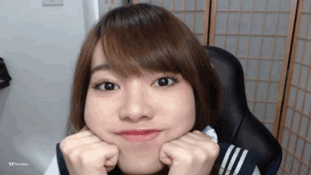 a girl is making a funny face with her hands on her face and the word ty is on the bottom
