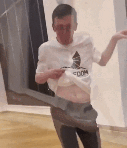 a man in a white shirt with the word dom on it is dancing .