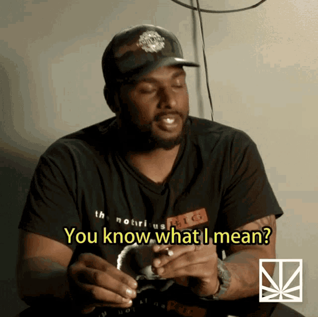a man wearing a black shirt that says " you know what i mean " on it
