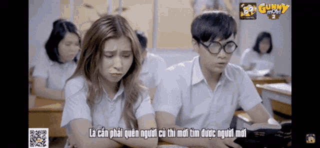 a man and a woman are sitting in a classroom with the word gunny on the top
