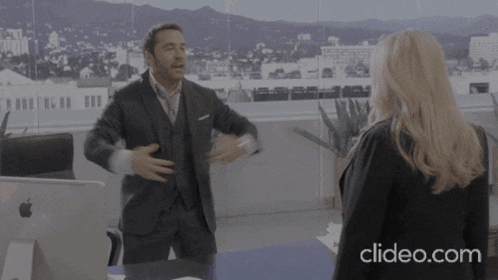 a man in a suit is yelling at a woman with a clipeo.com watermark on the bottom