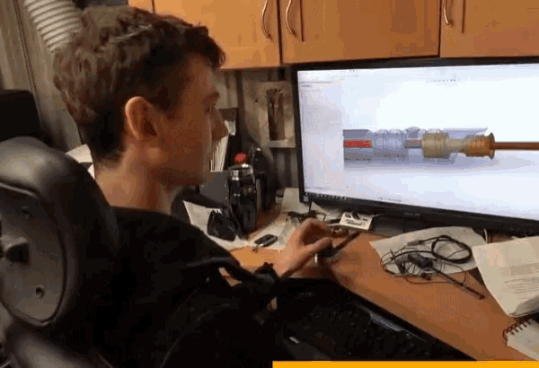 a man in a wheelchair is looking at a computer screen with a drawing of a pipe on it