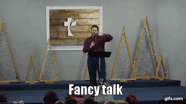 a man stands at a podium with fancy talk written on the bottom