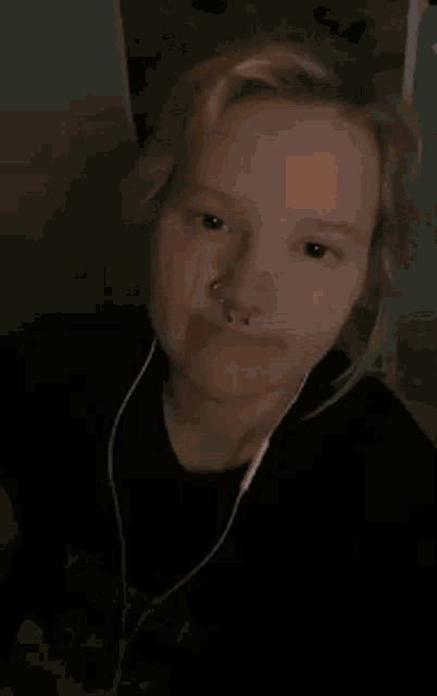 a woman is wearing headphones and has a bonk sticker on her face