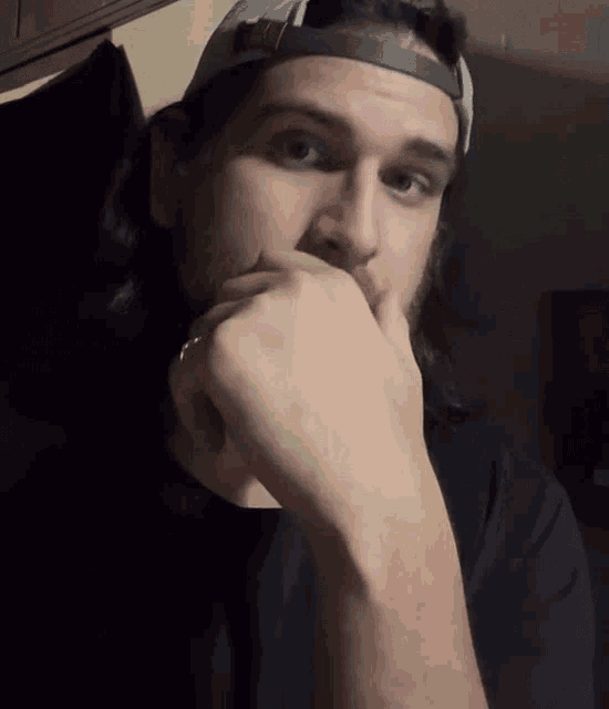 a man with long hair is wearing a hat that says mlb on it